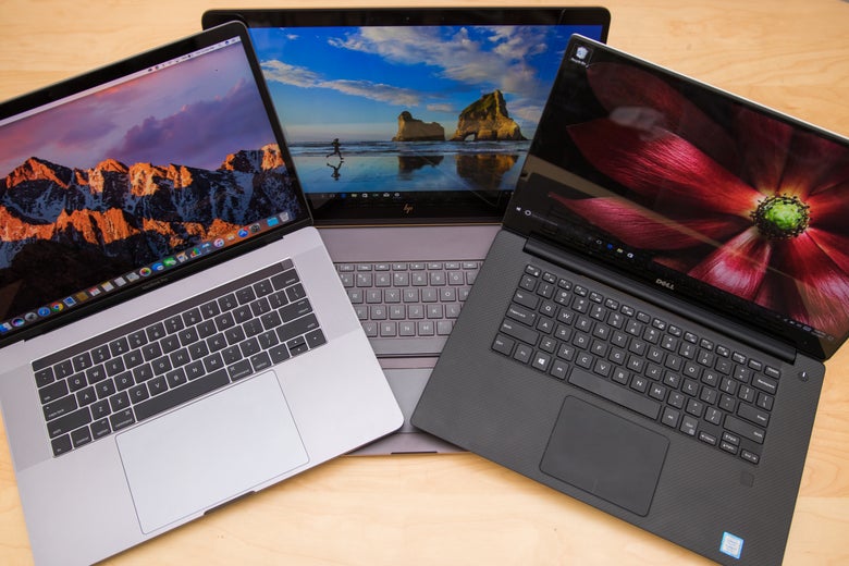 Three laptops open and stacked on one another.
